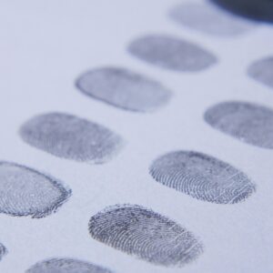 Close-up view of multiple fingerprints stamped on a white piece of paper, showcasing detail and clarity.