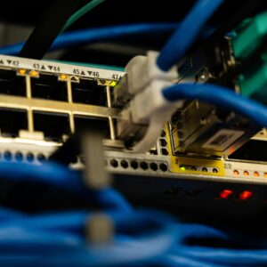 Close-up image of ethernet cables plugged into a network switch, showcasing IT infrastructure.